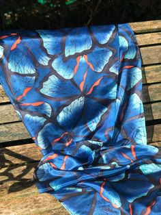 This beautiful, hand painted silk scarf is a wearable piece of art. Butterflies, in shade of blue with an orange accent, and outlined in black, have been hand painted onto the silk with specialist silk paint. The outline of the design is first drawn and then the colours are applied with brushes - the whole process takes many very enjoyable hours. The scarf has been professionally streamed in order to permanently fix the colours and preserve their vibrancy. This steaming process leaves the silk p Hand Painted Blue Silk Scarf For Summer, Artistic Blue Silk Scarves, Blue Hand Painted Silk Scarf, Blue Bohemian Hand Painted Silk Scarf, Blue Hand Painted Bohemian Silk Scarf, Bohemian Blue Hand Painted Silk Scarf, Artistic Blue Silk Scarf For Spring, Artistic Handmade Blue Silk Scarf, Artistic Blue Silk Scarf