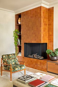 A tile-covered fireplace surround makes a bold statement in this living room. Mid Century Tile Fireplace, Fireplace Midcentury Modern, Brick Fireplace In Living Room, Fireplace Next To Stairs, Mcm Fireplace Wall, Contemporary Mid Century Living Room, 1970 Fireplace, Mid Century Electric Fireplace, Cover Up Brick Fireplace