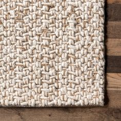 the textured carpet is made up of white wool and wood planks on top of a wooden floor