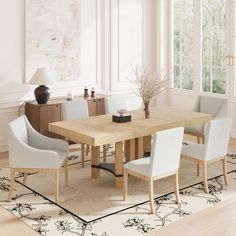 a dining room table with chairs and a vase on the rug in front of it