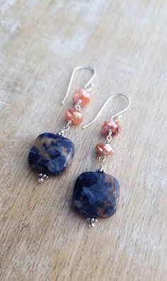 Sodalite Earrings Sterling Silver, Blue and Orange Earrings, Carnelian Earrings, Square Shaped Gemstone Dangle Earrings, Sunset Sodalite Dark indigo blue and orange sunset sodalite gemstones displaying lovely patterns dangle from mystic coated carnelian gemstones and sterling silver ear wires. The total length of the earrings is approximately 2 inches. The square orange sodalite gemstones are about 1/2 inch wide and 1/2 inch tall. They are faceted and polished on both sides. The blue and orange Natural Stone Agate Dangle Earrings, Agate Gemstone Dangle Earrings, Dangle Earrings With Natural Agate Stones, Agate Gemstone Bead Dangle Earrings, Agate Gemstone Drop Earrings, Agate Dangle Earrings With Ear Wire, Sunset Sodalite, Blue Gemstone Earrings, Carnelian Earrings