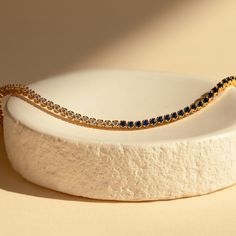 Make a shimmering statement with our Blue Diamond Tennis Bracelet. Elegant and dainty, it adds the perfect bold, finishing touch to your outfit for special occasions like anniversaries or weddings. A minimalist accessory sure to shine and a dazzling symbol of “something blue” for brides. Finish/Material: 18K Gold Over Brass ∙ Rhodium Over Brass Clasp: Box clasp and side prong closure Featuring a ~3mm Tennis Bracelet with half CZ Sapphire and half CZ Diamond stones Model showcases a romantic, min Dainty Blue Bracelets For Wedding, Elegant Blue Party Bracelets, Elegant Blue Bracelets With Sparkling Stones, Elegant Blue Gold-plated Bracelets, Elegant Adjustable Blue Gold Bracelet, Elegant Blue Adjustable Gold Bracelet, Elegant Adjustable Sapphire Bracelets, Elegant Sapphire Bracelets For Gift, Timeless Blue Round Bracelets