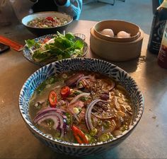 two bowls filled with soup sitting on top of a table