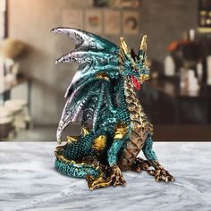 a green and gold dragon figurine sitting on top of a white countertop