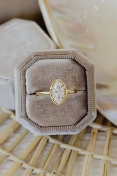 a ring with a diamond in it sitting on top of a cushion