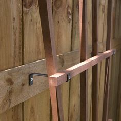 a wooden fence with metal brackets on it