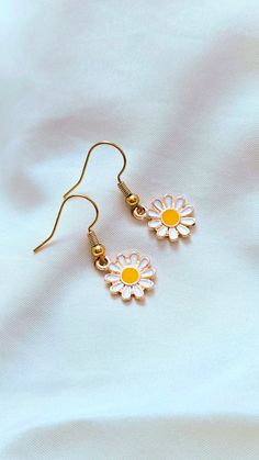 Add a touch of whimsy to your outfit with our Daisy Earrings. These adorable daisies will bring a smile to your face and brighten up any look. Perfect for adding a playful touch to your style. 🌼 Earring Details: White daisies Gold furnishings Dainty Spring Flower Earrings For Pierced Ears, Dainty Adjustable Flower Earrings For Spring, Whimsical Spring Flower Earrings With Ear Wire, Dainty White Earrings For Spring, White Flower-shaped Trendy Earrings, Trendy White Flower-shaped Earrings, White Daisy-shaped Jewelry For Spring, White Daisy-shaped Spring Jewelry, Whimsical Spring Earrings For Pierced Ears