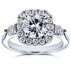 a white gold ring with an oval cut diamond surrounded by round diamonds