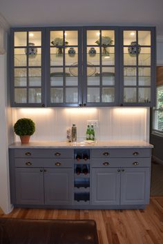 a kitchen with gray cabinets and white counter tops is lit up by recessed lighting