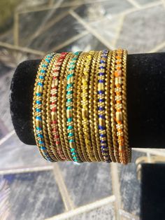 Add a touch of glamour to your special occasion with this beautiful multicoloured metal and thread work bangle set from My Jewel Box. The exquisite piece features natural stones and excellent cut grade that will surely catch everyone's attention. Perfect for engagement, wedding, anniversary, birthday, and Valentine's Day celebrations, this Indian/Pakistani bridalwear partywear jewellery is a great addition to your collection. The set is made of high-quality alloy material that guarantees durabil Traditional Stackable Bracelets For Festivals, Multicolor Cutdana Bracelets As Gifts, Multicolor Beaded Bangle Bracelets For Wedding, Multicolor Metal Bracelets For Festivals, Traditional Beaded Bangle As Gift, Traditional Multicolor Beaded Bracelets For Festive Occasions, Bohemian Adjustable Bangle For Diwali, Traditional Stackable Bangle For Festive Occasions, Gold Bohemian Beaded Bracelets For Festive Occasions