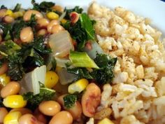 a white plate topped with rice, beans and greens