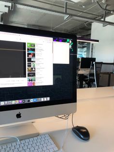 an apple computer monitor sitting on top of a desk next to a keyboard and mouse