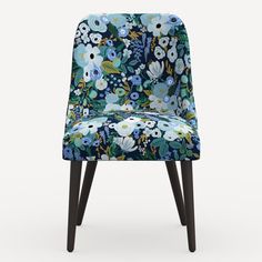 an upholstered chair with blue and white flowers on the back, in front of a gray background