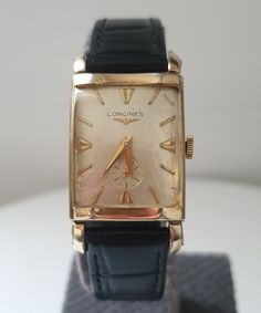 Great Longines Art Deco Hand Winding 10 k Gold Plated WristWatch Unisex, Vintage 1950's  Luxery Collection Watches,Best Gift For Her,Elegant Dress Timepeaces Very good vintage condition and rare Longines Art Deco 10k Gold Filled Tank watch from the probably 1950's . 28.8 mm length and 22.3mm width (without crown which suitable for unisex use.The watch has unusual triangle shape glass . The watch is powered by the rare hand-wound Longines movement by Longines), and functions perfectly. Rare and very beautiful collector's item. →The dial looks very-good and original. A Genuine black leather band added to watch may fits up to every size of wrist.The buckle and strap are non original . →Condition notes: The case has min signs of wear. General look very  nice as to its aged and chic. Pls check Retro Rectangular Watches For Formal Occasions, Retro Rectangular Formal Watches, Vintage Yellow Gold Rectangular Watch, Vintage Rectangular Yellow Gold Watch, Vintage Rectangular Dial Watch Accessories, Vintage Yellow Gold Rectangular Watch Accessories, Vintage Yellow Gold Watches As Gifts, Retro Yellow Gold Watch For Gift, Retro Yellow Gold Watch As Gift