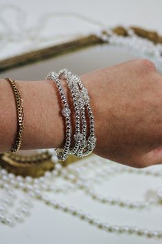 This Silver Beaded Bracelet Set of 5 is an exquisite and versatile addition to any jewelry collection. The set features 5 intricately designed silver bracelets that can be worn together for a statement look or individually for a subtle touch of elegance. Perfect for any occasion, this set adds a touch of sophistication and sparkle to any outfit. Upgrade your style with this beautiful set today! Elegant Silver Chain Bracelet With Silver Beads, Elegant Silver Chain Bracelet With Round Beads, Silver Dainty Beaded Bracelet, Elegant Silver Bangle Beaded Bracelets, Elegant Silver Beaded Bangle Bracelets, Dainty Silver Beaded Bracelet With Spacer Beads, Silver Metal Beaded Bracelets Dainty Style, Silver Stretch Bracelet With Spacer Beads, Silver Beaded Stretch Bracelet For Wedding