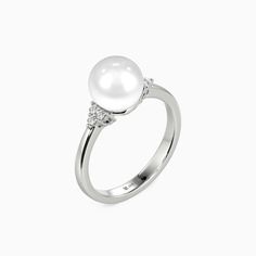 Celebrate everlasting love with this exquisite side-stone ring. A captivating pearl center stone radiates elegance, while trios of round gems on each side create an enchanting constellation of light. Additionally, this ring is crafted from highly polished precious metal, offering an irresistible luster and a comfortable fit. It is a symbol of love's timeless glow, designed to be cherished forever. *Each piece is handmade, resulting in a potential variance of 0.1-0.2mm during measurement. Please Classic White Cubic Zirconia Pearl Ring, Luxury Pearl White Round Pearl Ring, Side Stone Engagement Ring, Everlasting Love, Love Symbols, Precious Metals, Stone Rings, Fresh Water, Personalized Jewelry