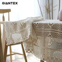 a table with a white crochet doily on it next to a wooden chair