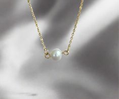 Enhance your feminine grace with our Single Pearl Necklace. Made with a dainty, cute design, this necklace will add a touch of girly elegance to any outfit. Stand out and make a statement with this unique and sophisticated accessory. 15 inches long + 2 inches ext 18K PVD gold plated stainless steel Fresh Water Pearl Pendant Non Tarnish And Water Resistant Elegant Gold Charm Necklace With Simple Design, Dainty Gold Pearl Necklace Gift, Elegant Hypoallergenic Charm Necklace Gift, Simple Pearl Necklace With Clavicle Chain As Gift, Simple Pearl Clavicle Chain Necklace As Gift, Dainty Pearl Necklace With Clavicle Chain For Gift, Dainty Charm Necklace With Adjustable Chain For Formal Occasions, Dainty Charm Necklaces With Adjustable Chain For Formal Occasions, Dainty Pearl Clavicle Necklace Gift