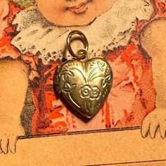 "ONE vintage tiny locket in a heart shape with a floral motif. Each old stock locket has been slightly hand buffed for a warm, buttery patina. A diminutive 1/2\" when closed, this can possibly hold tiny photos inside. Each is unique in patina and small imperfections. COLOR: yellow brass SIZE: just over 1/2\" tall CONDITION: vintage old stock ONE TINY LOCKET" Vintage Nickel Free Heart Jewelry, Vintage Heart Locket Necklace Nickel Free, Antique Heart Locket Necklace For Memorial, Vintage Charms Jewelry For Valentine's Day, Heart-shaped Vintage Locket Necklace For Memorials, Antique Locket Necklace For Valentine's Day Memorial, Heart Locket Necklace With Vintage Charm For Memorial, Antique Memorial Locket Necklace For Valentine's Day, Heart Shaped Memorial Locket Necklace With Vintage Charm