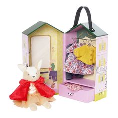 a stuffed animal is in front of a doll's house with its door open