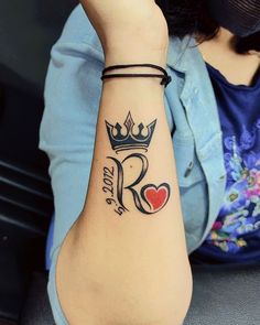 a woman with a tattoo on her arm and a crown tattooed on her left wrist