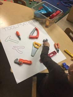 a young child is drawing letters on a piece of paper