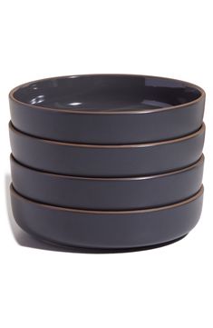 four dark grey bowls stacked on top of each other with brown rims in the middle