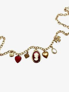 This charm necklace is the perfect mix of classic and trendy... made of mostly vintage charms on a vintage gold-plated chain, we can't even pick our favorite charm! 7 charms hang from this 18" vintage oval-cable chain: tiny brass cat face vintage powder-coated red heart vintage brass dice charm vintage glass/ gold plated cameo charm vintage brass puffy heart clear, natural quartz tear-drop shaped pendant, vermeil (18K gold plated) vintage brass bow Details: 18" in length, but can be clipped to w Vintage Necklaces With Vintage Charm For Valentine's Day, Vintage Metal Charm Necklace, Vintage Charm Necklaces For Valentine's Day, Vintage Gold Necklaces With Heart Charm, Vintage Metal Necklace With Logo Charm, Vintage Gold-tone Necklace With Logo Charm, Vintage Gold-tone Jewelry With Logo Charm, Gold Necklace With Heart Charm For Vintage Collection, Vintage Metal Heart Charm