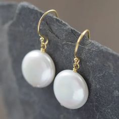 These earrings showcase AAA-grade, high-luster pearls that radiate pure sophistication. Each pearl, with its unique natural beauty, varies slightly in size, ranging between 12-14mm in a captivating coin shape. Adorned with delicate (but durable) gold-filled wires, these earrings effortlessly enhance the white pearls' inherent allure. We take pride in meticulously pairing each pearl to ensure a harmonious duo. 14k Yellow Gold Filled Round Pearl Earrings, Delicate Round Pearl Earrings With Ear Wire, Dainty Round Pearl Earrings With Ear Wire, Classic White Pearl Earrings In 14k Gold, Everyday Pearl Earrings With Pearl Charm, Delicate Hypoallergenic Round Pearl Earrings, Everyday Round Pearl Earrings With Ear Wire, Everyday Pearl Charm Earrings, Hypoallergenic Delicate Round Pearl Earrings