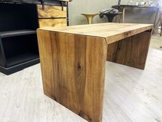 a wooden desk sitting on top of a hard wood floor next to a black cabinet