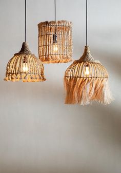 three light fixtures hanging from the ceiling with fringes and lightshades on them