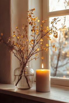 Cozy Fall Decor: A lit candle and a glass vase with autumn branches sit on a windowsill, perfect for minimalistic fall home decor ideas. Autumn Window Decorations, Craft Fairy, Autumn Window, Flowers House, Personalized Centerpieces, Whimsical Fall, Chic Candles, Minimalist Candles, Centerpieces Diy