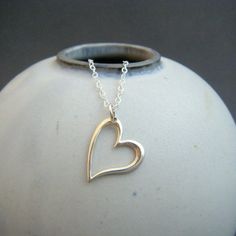 "small slanted heart necklace. sterling silver open heart. delicate dainty pendant. simple everyday modern jewelry. romantic special gift A small modern sterling silver slanted heart, paired with a simple chain, perfect special gift....for yourself or someone you love. - Sterling silver open heart, just over 1/2\" across (13 mm) at widest point.. - Necklace is solid sterling silver 1.5 mm cable chain, lobster clasp, and locking circle jump rings, all solid sterling silver. - Shiny finish, hangs Silver Delicate Open Heart Necklace, Delicate Silver Open Heart Necklace, Simple Open Heart Silver Jewelry, Simple Silver Open Heart Jewelry, Simple Sterling Silver Heart Charm Necklace, Delicate Sterling Silver Open Heart Necklace, Dainty Silver Open Heart Necklace, Simple Sterling Silver Heart Pendant Necklace, Simple Open Heart Necklace For Valentine's Day