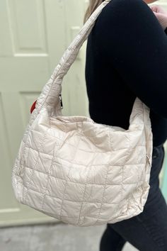 You'll be able to carry all the things in this trendy quilted puffer shoulder bag. This bag features two zipper pockets on the front along with two small compartments and another zipper pocket inside the main. Super lightweight and comfortable on the shoulder. Dimensions: 19"L, 13"H, 6"W Quilted Beige Shoulder Bag For Travel, Versatile Quilted Beige Bag, Functional Quilted Shoulder Bag With Double Handle, Beige Quilted Tote Shoulder Bag, Designer Quilted Beige Shoulder Bag, Hobo Bag, Zipper Pocket, Inside Pocket, Puffer