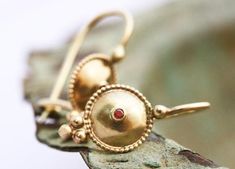 Exquisite, antique-style very small ruby and 14k, 18k or 22k solid gold hook drop earrings. These amazing drop earrings have a decorated domed disc and a tiny red ruby set in the middle of it. At the bottom of the disc on each earring, there are three gold dots that add character to these boho earrings. These earrings are elaborate and delicate but still very noticeable. They have a unique eye-catching boho look that will go with and upgrade any outfit.Ruby is the birthstone of July and is consi Historical Yellow Gold Drop Earrings, Yellow Gold Historical Drop Earrings, Yellow Gold Drop Earrings With Historical Design, Traditional 14k Gold Drop Earrings, Yellow Gold Earrings With Historical Design As Gift, Traditional Yellow Gold Earrings With Historical Design, Antique Yellow Gold Pendant Earrings, Antique Pendant Yellow Gold Earrings, Traditional Historical Design Earrings For Wedding