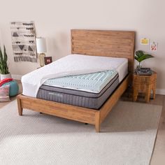 a bed with a wooden headboard and mattress on top of it in a room