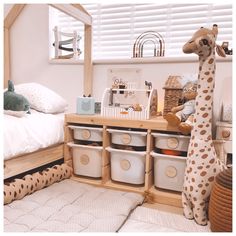 a giraffe stuffed animal sitting next to baskets in a room filled with toys