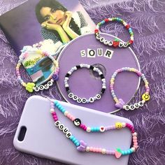 the phone case is next to two bracelets and a cellphone with an advertisement on it