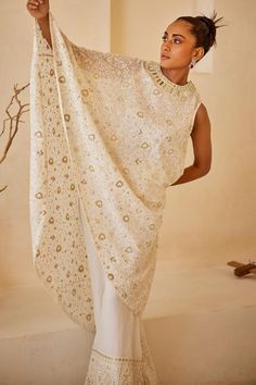 White flared asymmetric cape featuring all over chikankari embroidered floral motifs with sequin embellishments.
Components: 1
Pattern: Embroidered
Type Of Work: Chikankari,Sequin
Neckline: Round
Sleeve Type: Asymmetric
Fabric: Georgette
Color: White
Other Details: 
Flared silhouette
Note: Pant worn by the model is not for sale
Occasion: Cocktail,Sangeet - Aza Fashions Asymmetrical Cape, Cape For Women, Chikankari Embroidery, Nyc Studio, White Flares, Pattern Embroidery, Western Wedding, Wedding Service, Sequin Fabric