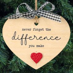 a wooden ornament hanging on a christmas tree saying never forget the differences you make