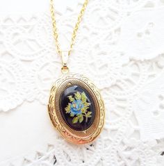 "A gorgeous gold plated photo locket adorned with a lovely vintage black glass limoges with blue rose and gold and green leaves dangles so pretty from a 16k gold plated link chain with lobster clasp. Locket has a lovely floral etched pattern Total length of chain measures 18\" Locket measures 23x30mm Cameo measures 18x13mm Locket is high quality and nickel free Your purchase will come beautifully wrapped ready for gift giving" Gold Necklace With Black Enamel Oval Pendant, Gold Oval Necklace With Black Enamel, Vintage Gold Necklace With Pressed Flowers, Vintage Pressed Flowers Jewelry Keepsake, Antique Black Enamel Necklace For Gift, Vintage Pressed Flowers Keepsake Jewelry, Victorian Black Enamel Necklace For Gift, Antique Black Enamel Necklaces For Gift, Heirloom Black Enamel Jewelry For Gift