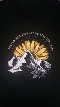 a black t - shirt with a yellow sunflower on the front and words that read, it's good times and we will travel