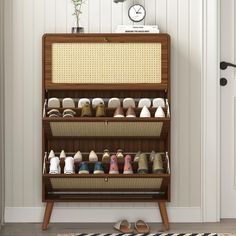 there are many pairs of shoes on the shelf in front of the door and clock