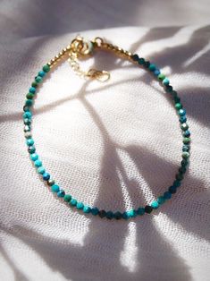 "A dainty jewelry design for appeasing the star within, this adjustable gold-filled bracelet comes beaded with tiny beads carved from all natural turquoise gemstone. ✦ DETAILS ✦ ✧ Name: Kalilinoe (kah lee lee noh eh) - rain. ✧ Adjustable Length from: 6.5\"-8\". ✧ Genuine 2.5mm faceted tiny Turquoise Beads. ✧ 14kt Gold Filled Components, Extender, and Clasp. ✧ All Ke Aloha Jewelry pieces come packaged thoughtfully, beautifully, and ready for gift giving. ✦ MORE GOLD BRACELETS ➤ https://www.etsy.c Hawaii Jewelry, Tiny Beads, Turquoise Bead Bracelet, Dainty Bracelets, Layered Bracelets, Natural Turquoise, Dainty Jewelry, Turquoise Gemstone, Turquoise Beads