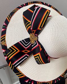 ombines timeless elegance with vibrant cultural flair. Handcrafted with care, this hat features a beautifully woven straw base adorned with bold African print fabric, offering both style and sun protection. Perfect for church services, outdoor events, or simply adding a touch of sophistication to your outfit, this hat blends tradition with modern design. Lightweight and breathable, it's as comfortable as it is striking. Elevate your look with a hat that celebrates heritage and craftsmanship. One size: should fit all. Adjustable Wide Brim Boater Hat For Church, Multicolor Hats For Kentucky Derby And Beach, Multicolor Hat For Beach And Kentucky Derby, White Woven Hat Bands For Summer, White Woven Hat Band For Beach, White Woven Hat Bands For Beach, Elegant White Woven Sun Hat, Multicolor Sun Hat For Beach And Kentucky Derby, Traditional White Panama Hat With Wide Brim