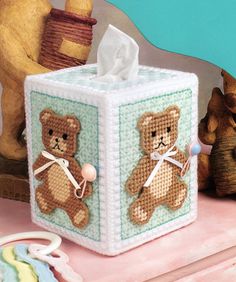 a tissue box with a teddy bear on it and two other bears in the background