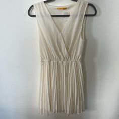 Cream Chiffon Pleated Dress By James Lacroix Purchased From Boutique In Lower Manhattan, Nyc V-Neck At Front With Snap At Bust Can Be Worn With Standard Bra Lined Ruffle In Front Along The Neckline Elastic Waist For Comfortable And Flattering Fit Measures Approximately 37” From Top Of Shoulder To Bottom Hem, 19” Flat Across Armpit-To-Armpit, 13” To 21” Flat Across Waist (Elastic) Excellent Condition, Nwt, Euc Has Been Stored In Smoke And Pet Free Home Closet Retail Us $118 Summer Pleated V-neck Chiffon Dress, Elegant White Chiffon V-neck Dress, Elegant White V-neck Chiffon Dress, Fitted Sheer V-neck Chiffon Dress, Pleated V-neck Chiffon Dress For Summer, White Sheer V-neck Mini Dress, White Sleeveless Chic Chiffon Dress, Chic White Sleeveless Chiffon Dress, White Flowy Chiffon V-neck Dress