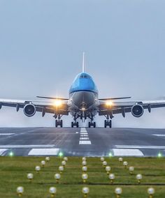 an airplane is taking off from the runway at night, with its landing gear down