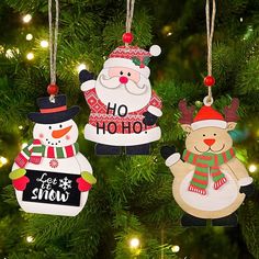 three ornaments hanging from a christmas tree in the shape of santa and snowman, one with