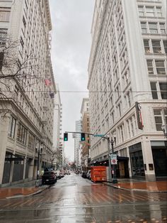 an empty city street with tall buildings on both sides and traffic lights in the middle